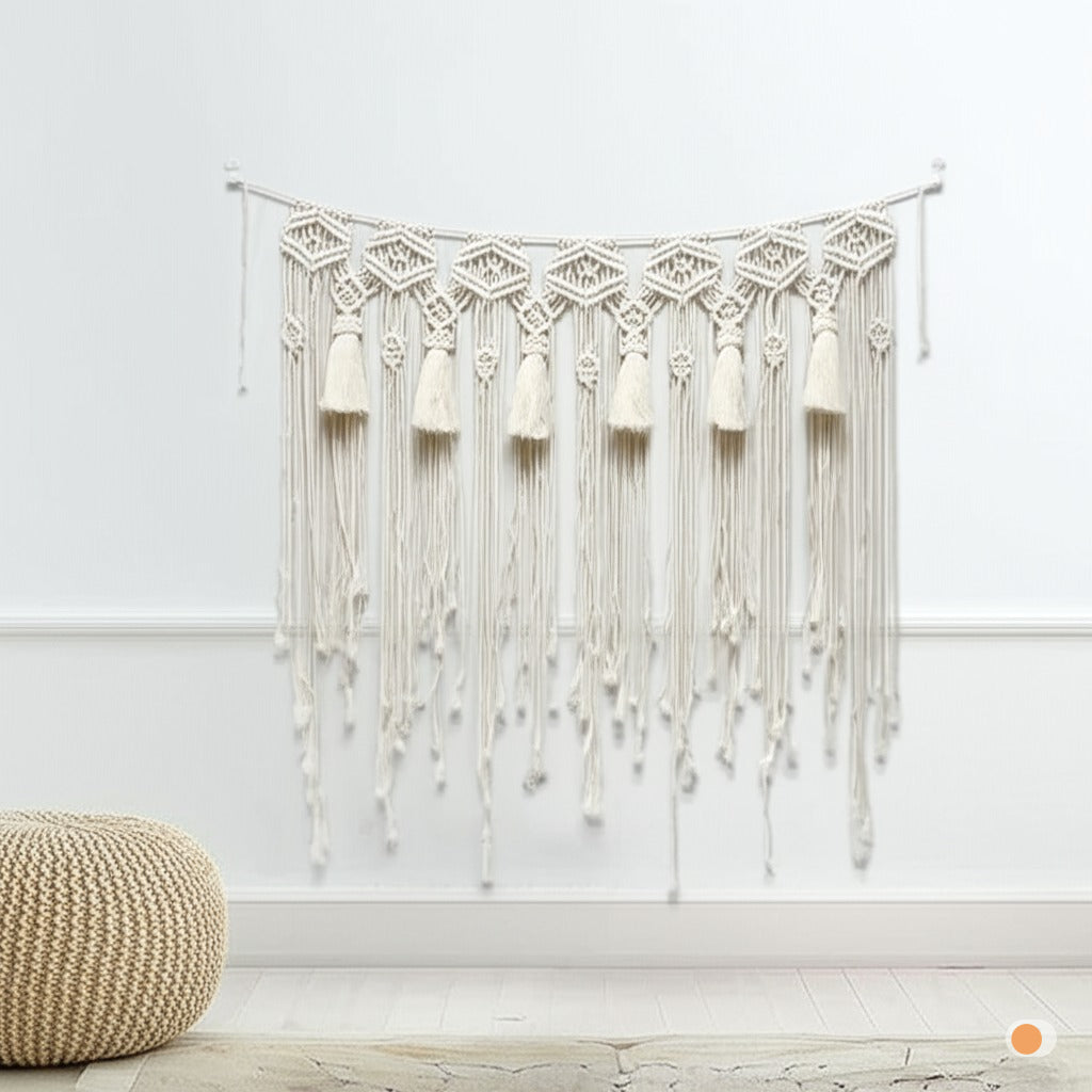 Rideau macramé décoratif en coton beige.
Design bohème avec des motifs géométriques et des franges.
Suspendu sur un mur blanc, ajoutant une touche artisanale et chaleureuse.
Présenté dans un intérieur épuré avec un pouf en rotin et un sol clair.