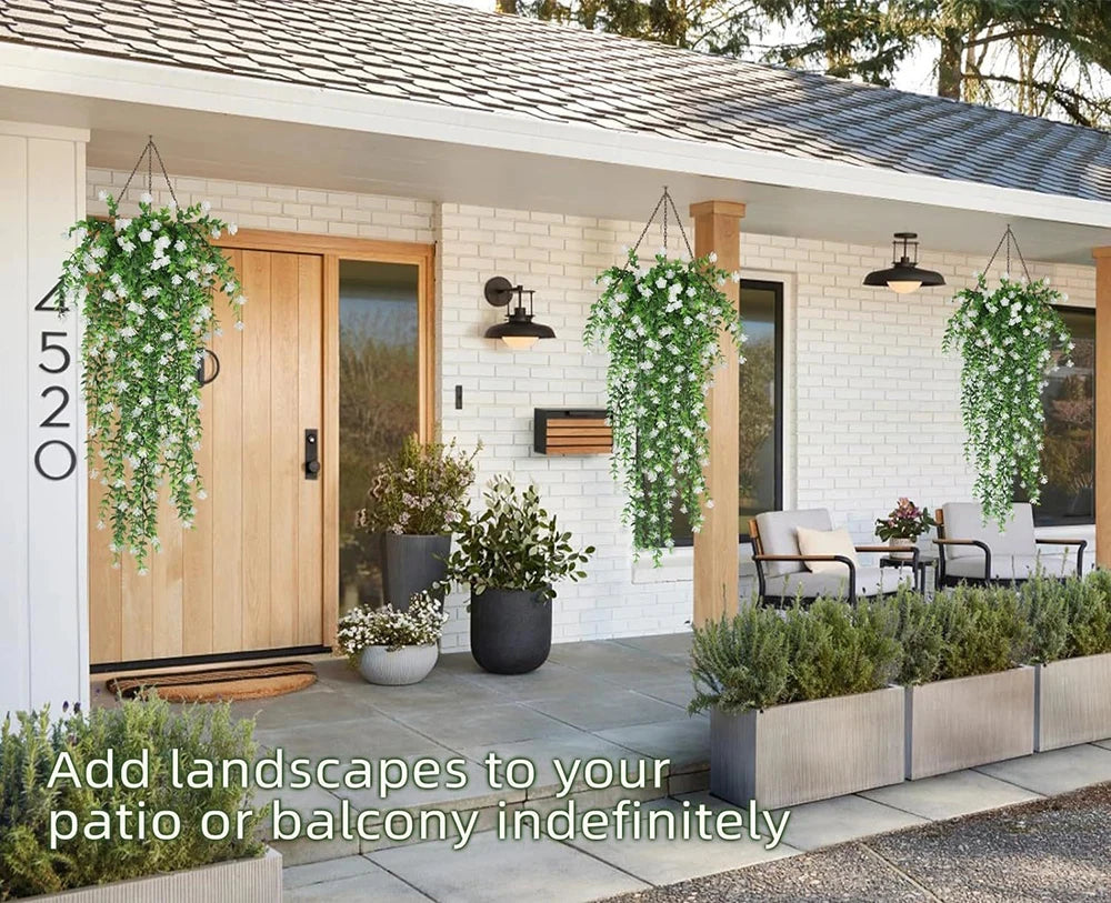 Entrée de maison moderne avec porte en bois, mur de briques blanches, plantes artificielles tombantes Cascade Bohème en vert et blanc, sièges extérieurs, verdure en pot - ajoutez un décor végétal luxuriant à votre terrasse ou balcon qui dure indéfiniment.