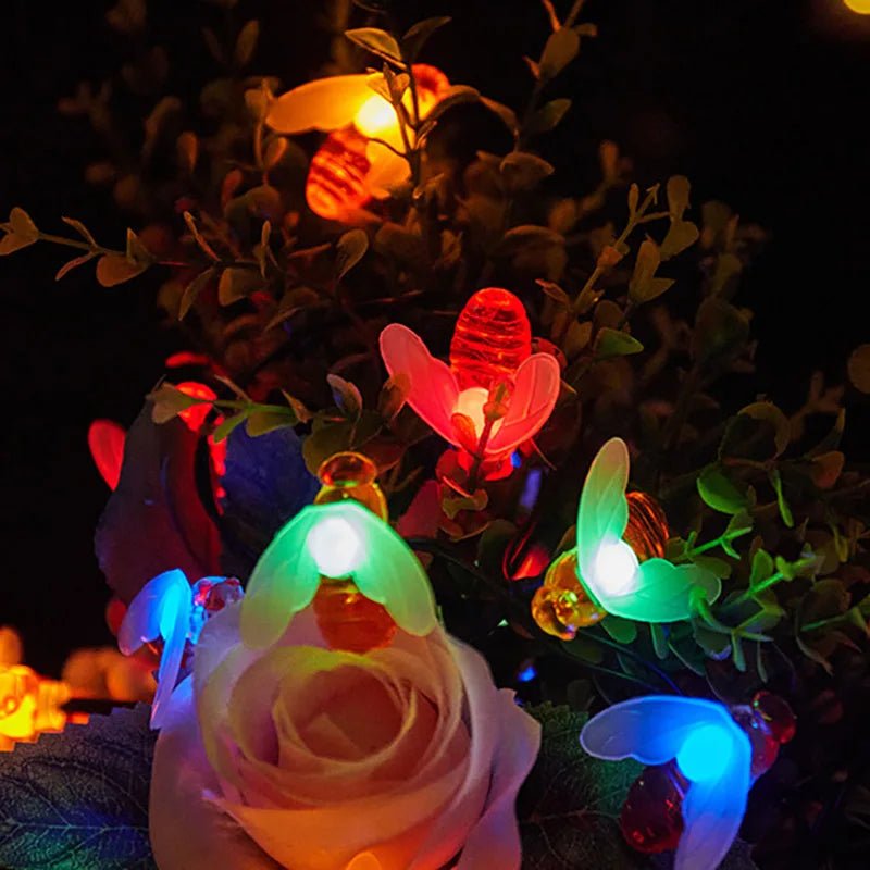 Guirlande solaire exterieur | Abeilles Solaires avec des lumières colorées et une fleur, créant une ambiance festive.