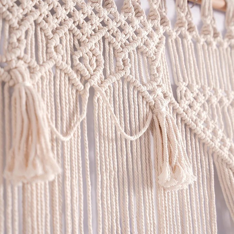 Ce gros plan met en lumière la texture délicate d'un rideau macramé.
Les motifs complexes en nœuds de fils de coton écrus créent un jeu de lumière et d'ombre subtil.
De longues franges pendantes ajoutent une touche bohème et artisanale à cette pièce décorative.
Un exemple raffiné de l'art du macramé transformé en un élégant rideau pour une ambiance chaleureuse.