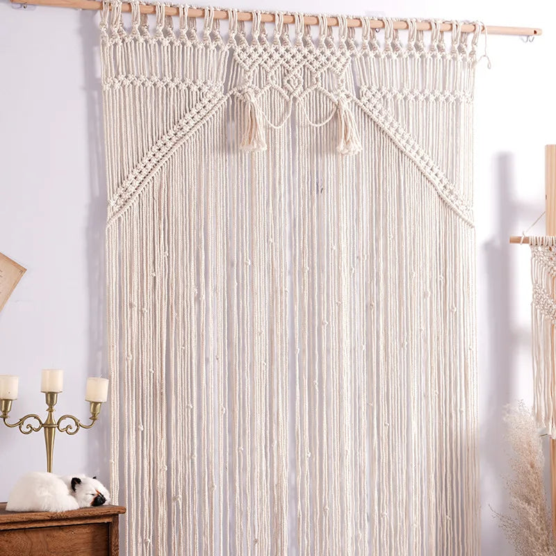 Un rideau en macramé de couleur crème, suspendu à une tringle en bois, orne une pièce lumineuse.
Le motif complexe du macramé crée une texture aérée et décorative.
Des longues franges pendantes ajoutent une touche bohème et élégante.
Parfait pour filtrer la lumière et décorer une fenêtre ou une porte.