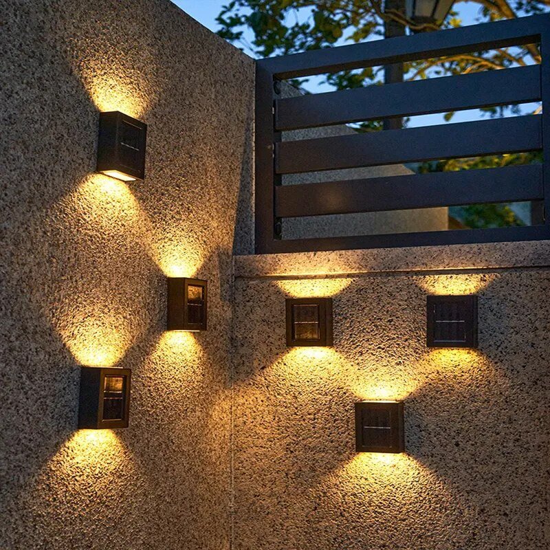 Lampe solaire jardin haut de gamme illuminant un mur de jardin moderne avec élégance.