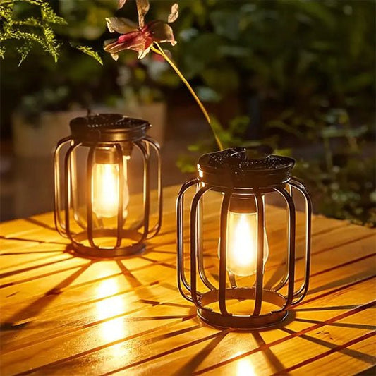 Deux lampes solaires de jardin haut de gamme illuminent une table en bois.