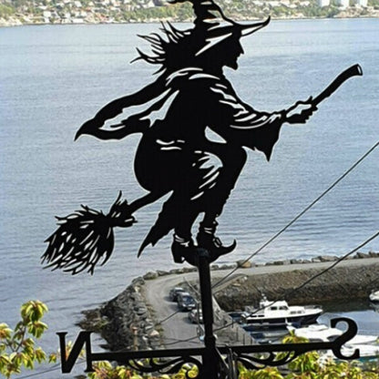 La girouette de toit-Sorcière représente la silhouette d'une sorcière sur son balai, projetant sa magie sur un lac serein. Les bateaux dérivent près du rivage rocheux, guidés par les directions nord et sud de la girouette, se fondant harmonieusement dans la nature dans cette décoration extérieure envoûtante.