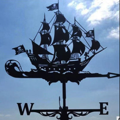Une « Girouette de jardin-Galion » en forme de bateau pirate se dresse sur un ciel nuageux, avec des voiles avec des drapeaux pirates, une flèche marquée et des directions pour l'ouest et l'est, idéale pour toute décoration extérieure.