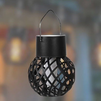 Une décoration Mafrenesie noire et sphérique Lanterne solaire | Flamme au design en treillis et poignée en métal est suspendue élégamment sur un fond flou, sa bougie effet flamme vacillant chaleureusement pour une ambiance extérieure enchanteresse.