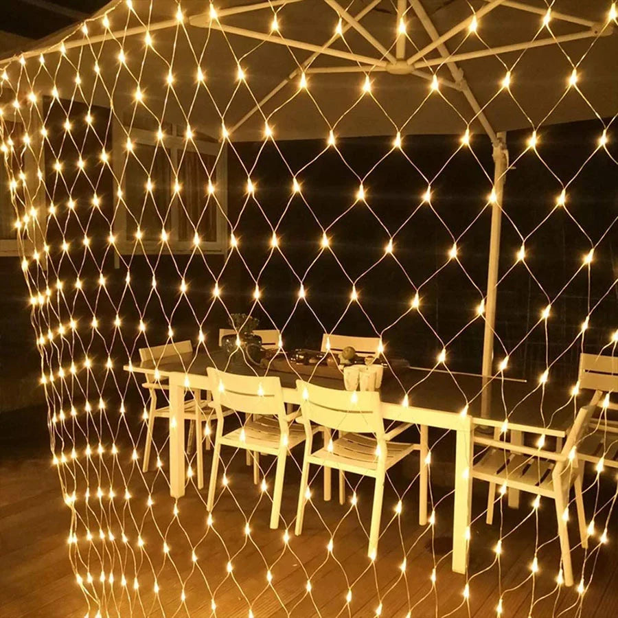 Guirlande lumineuse rideau solaire illuminant une terrasse extérieure chaleureuse.