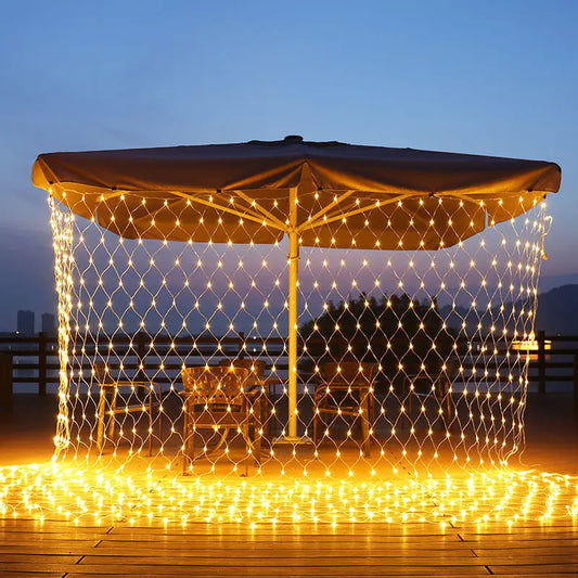 Guirlande rideau solaire illuminant une terrasse avec parasol, créant une atmosphère chaleureuse.