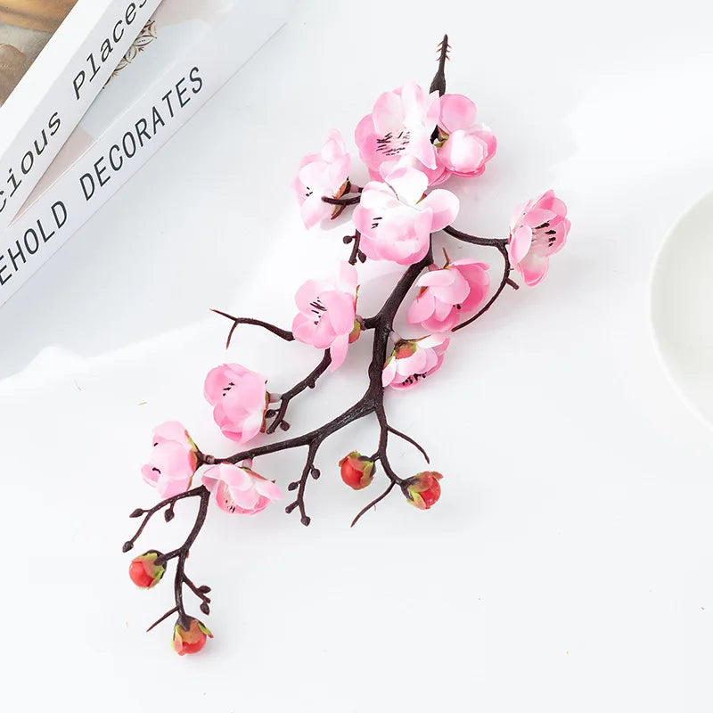 Branche de prunier en fleurs rose, plante artificielle décorative, sur fond blanc.