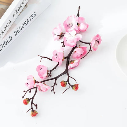 Branche de prunier en fleurs rose, plante artificielle décorative, sur fond blanc.