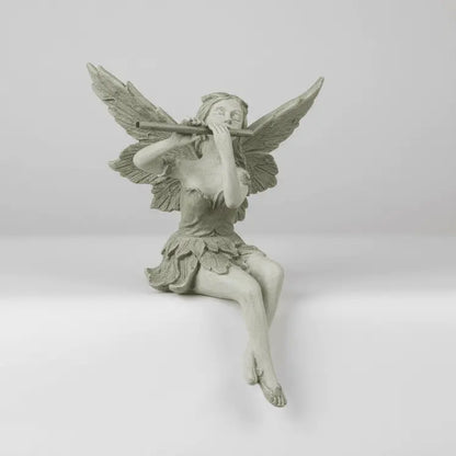 Décoration jardin fée résine assise jambes croisées ailes déployées packshot professionnel fond gris clair éclairage neutre