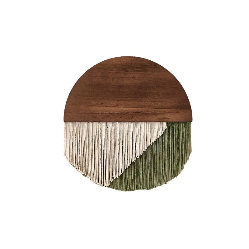 Décoration murale en macramé suspendue sur un support en bois semi-circulaire. Les fils de coton ivoire et vert olive forment un motif en V. L'objet mesure 40 cm de large et 40 cm de haut