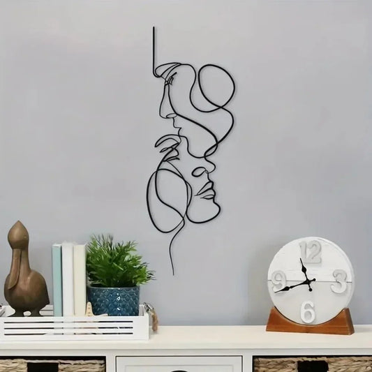 Décoration murale intérieure abstraite minimaliste en métal représentant deux visages stylisés.
