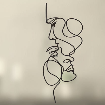 Décoration murale intérieure abstraite minimaliste en métal représentant deux visages stylisés.