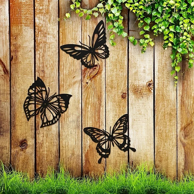 Trois Decoration Murale Papillons noirs stylisés ornent une clôture en bois rustique.