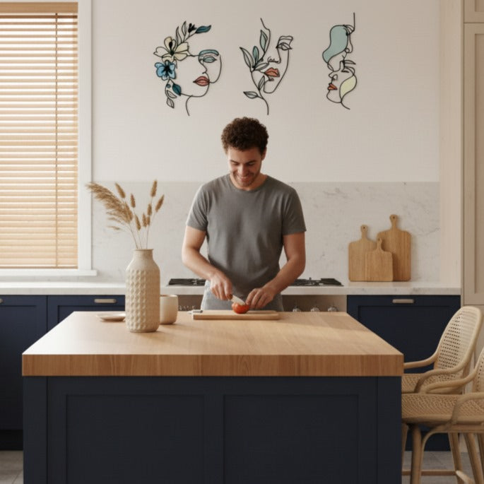 Jeune homme souriant cuisinant dans une cuisine moderne avec une Decoration murale pour cuisine élégante représentant des visages floraux abstraits.