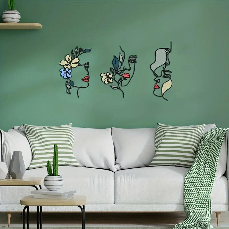 Trois Decoration murale pour cuisine stylisées, des visages fleuris en ligne, décorent un mur vert.