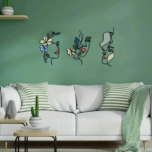Trois Decoration murale pour cuisine stylisées, des visages fleuris en ligne, décorent un mur vert.
