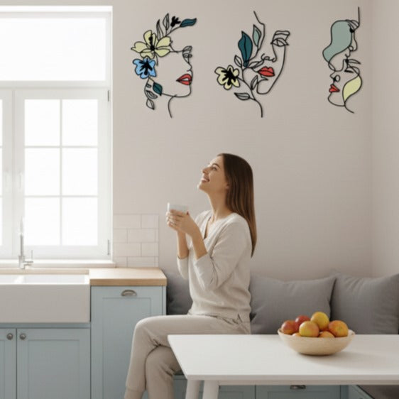 Femme souriante admirant trois Decoration murale pour cuisine abstraites et fleuries.