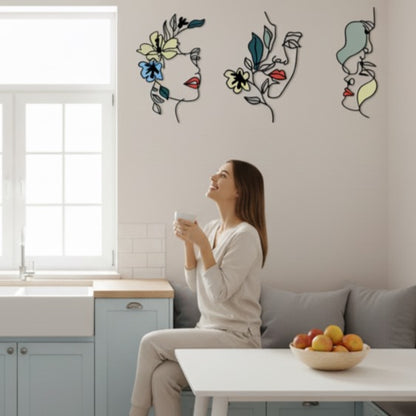 Femme souriante admirant trois Decoration murale pour cuisine abstraites et fleuries.