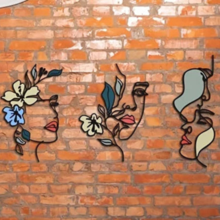 Decoration murale pour cuisine silhouettes féminines artistiques en métal noir avec des fleurs colorées, sur un mur de briques.