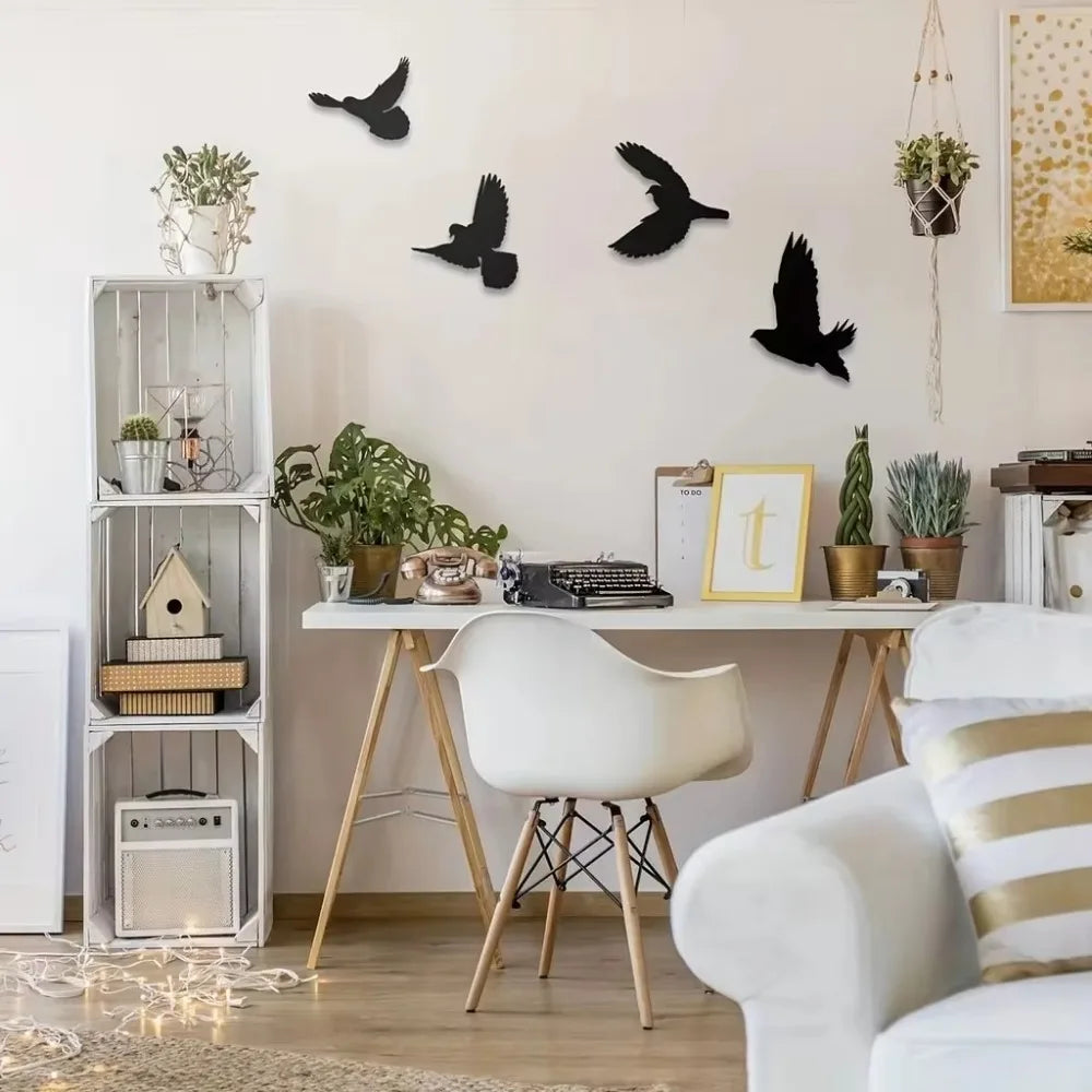 Quatre oiseaux noirs Decorations Murales Extérieures en vol, égayant un mur blanc au-dessus d'un bureau épuré.