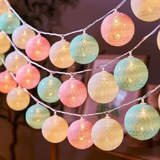 Guirlande lumineuse aux boules multicolores pastel pour une ambiance douce.