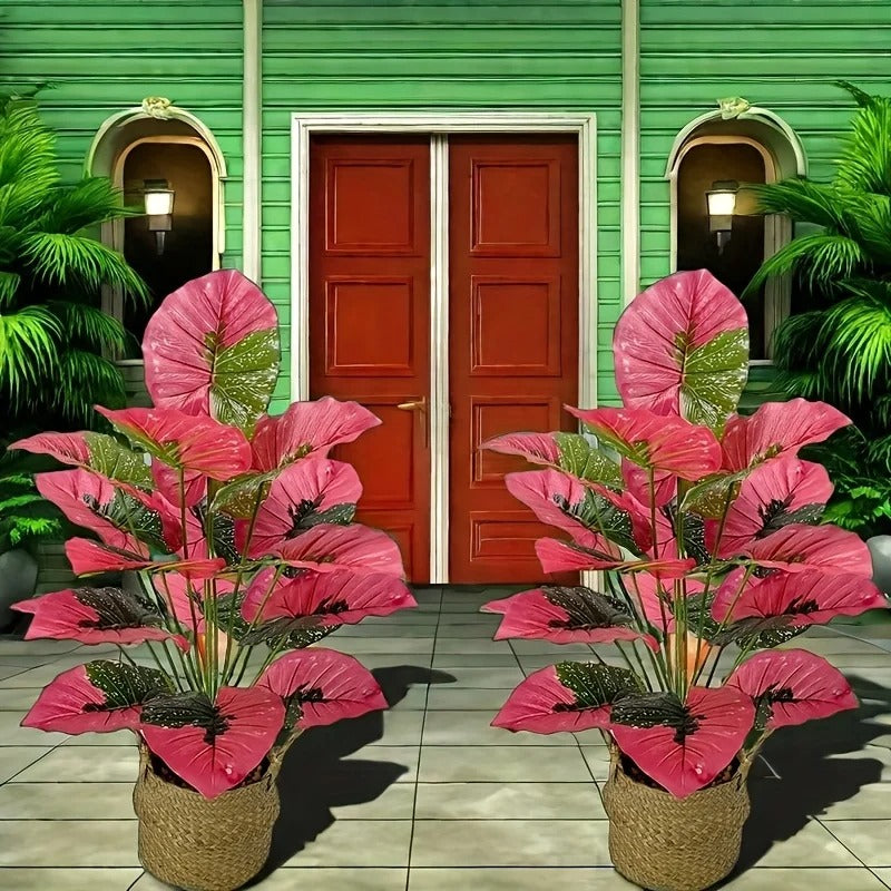 Grande plante artificielle de Colocasia rose devant une porte rouge, ambiance tropicale.