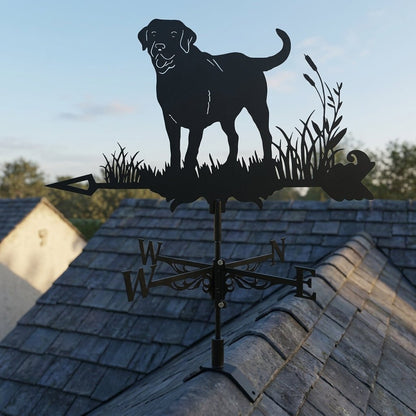 Girouette Animée avec motif de chien Labrador fixée sur la toiture d'une maison se découpant sur un ciel bleu.