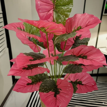 Grande plante artificielle Caladium rose et verte, feuillage luxuriant, fond blanc.