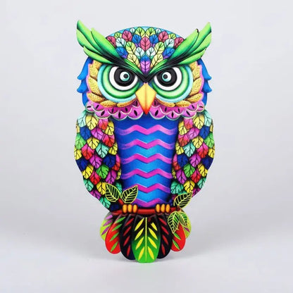Gros plan décoration de jardin chouette métal couleurs vives psychedéliques détails géométriques plumage finitions brillantes reflets