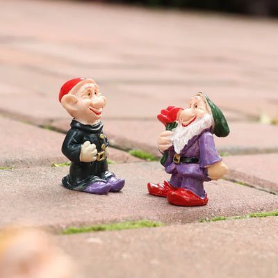 Gros plan nain de jardin rigolo détails visage souriant expressif barbe blanche texturée finitions artisanales 