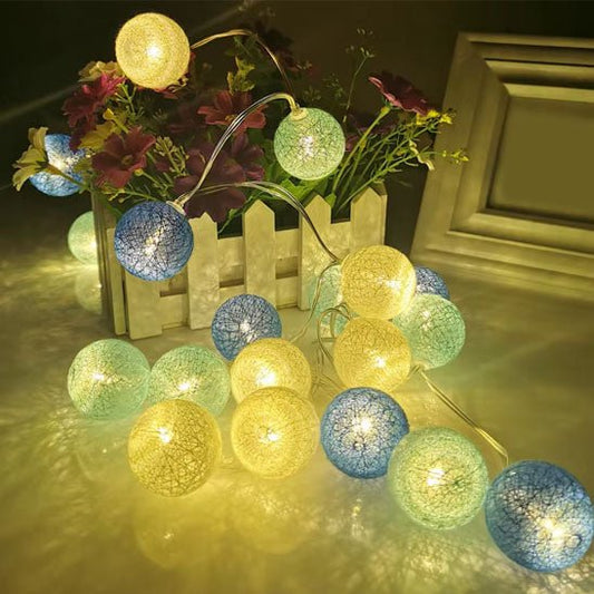 Guirlande lumineuse de boules en coton, couleurs douces, décoration intérieure chaleureuse.