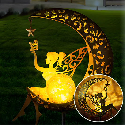 La décoration Mafrenesie LunaGlow est une Lampe solaire jardin haut de gamme fantaisiste représentant une silhouette de fée sur un croissant de lune. Elle projette une lumière dorée chaude avec des découpes en forme détoiles et de fleurs, tandis que la fée tient un papillon près dun orbe lumineux, créant ainsi une illumination magique.