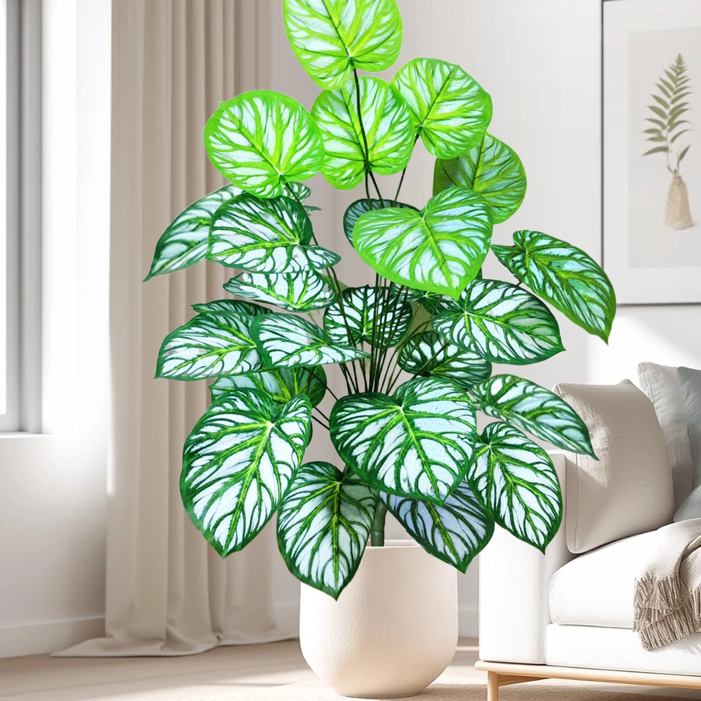 Grande plantes artificielles pour balcon d'intérieur décorative, feuilles vertes et blanches, dans un pot crème, près d'un canapé blanc.