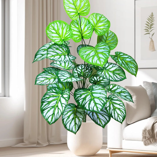 Grande plantes artificielles pour balcon d'intérieur décorative, feuilles vertes et blanches, dans un pot crème, près d'un canapé blanc.