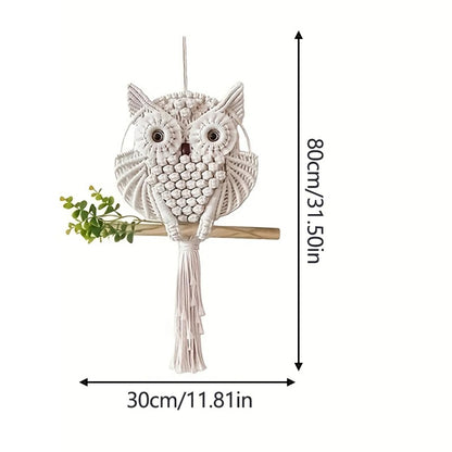 Le Macramé-Hibou est une décoration murale en forme de hibou blanc aux grands yeux, sur un bâton en bois et orné d'une feuille verte. Une touche bohème et artistique pour votre décoration. Dimensions : 80 cm de haut, 30 cm de large.