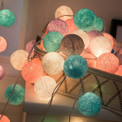 Guirlande lumineuse de boules en coton multicolores, créant une ambiance chaleureuse.
