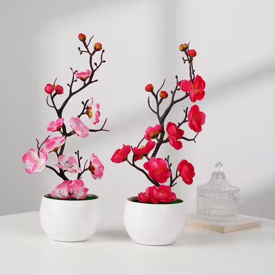 Deux élégantes plante artificielle de cerisier en fleurs, roses et rouges, en pots blancs.