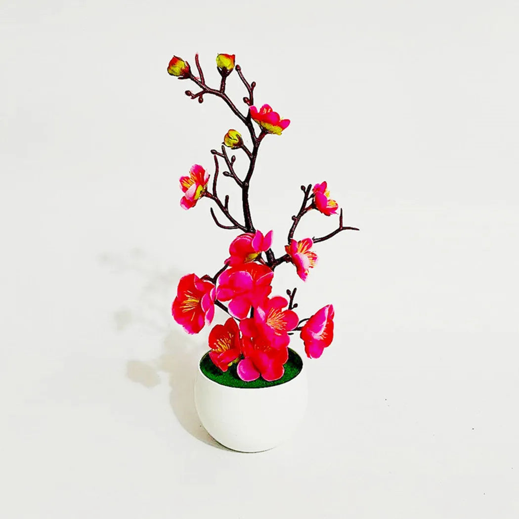 Plante artificielle : Un pot blanc contient des fleurs de cerisier roses éclatantes.
