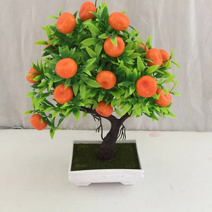 Sur cette image, on voit une petite plante artificielle. Elle représente un agrume avec de nombreuses oranges vives. Les feuilles vertes en plastique complètent l'aspect décoratif de cette plante artificielle. Le tout est placé dans un pot carré blanc garni d'une imitation de mousse. Cette plante artificielle est idéale pour ajouter une touche de couleur sans nécessiter d'entretien.