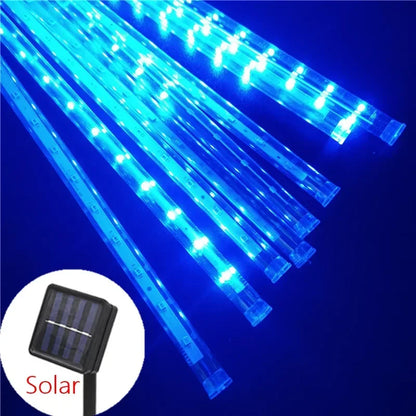 La Guirlande solaire extérieure | Joie solaire présente des lumières de pluie de météores à LED bleues sur fond sombre pour un éclairage écologique. Une image en médaillon montre un panneau solaire étiqueté « Solaire », démontrant sa dépendance à l'énergie solaire avec un cadre noir et des cellules solaires visibles.