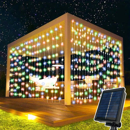 Sous le ciel étoilé, un kiosque est éclairé par la lueur vibrante de la Guirlande solaire extérieur-rideau | Lumière heureuse. Un panneau solaire alimente ces charmantes lumières, tandis qu'à l'intérieur, un hamac sur la terrasse en bois invite à la détente dans cette ambiance extérieure enchanteresse.