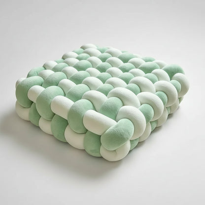 Coussin en velours noué blanc et vert sur canapé beige - décoration salon