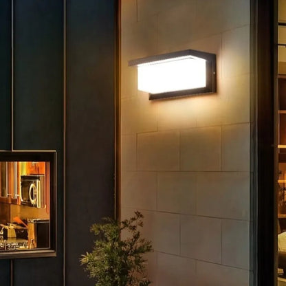 Lapplique murale LED Mafrenesiedecoration | inégalée LED illumine un mur carrelé beige près dune fenêtre, avec une petite plante en dessous. La lumière intérieure chaleureuse contraste avec lextérieur plus sombre, offrant des économies dénergie et du style.