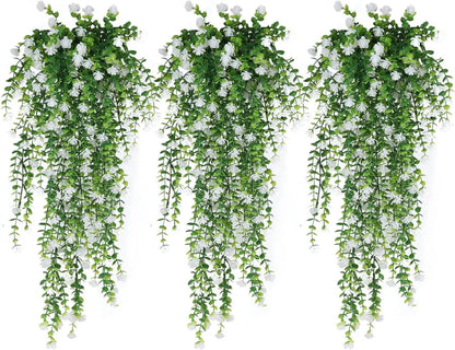 Créez un décor végétal luxuriant avec trois plantes tombantes artificielles Cascade Bohème, comportant des feuilles vertes luxuriantes et des fleurs blanches, disposées verticalement sur un fond blanc pour une atmosphère apaisante.