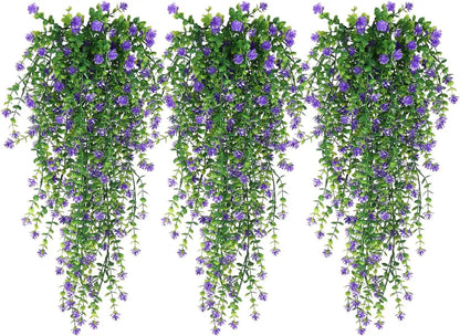 Trois bouquets de Plantes artificielles tombantes-Cascade Bohème aux petites fleurs violettes pendent côte à côte sur un fond blanc, formant un étalage vert luxuriant et vibrant.