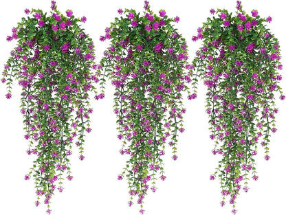 Trois Plantes artificielles tombantes-Cascade Bohème aux feuilles vertes luxuriantes et aux fleurs violettes et roses vibrantes créent un décor végétal luxuriant, magnifiquement présenté sur un fond blanc.