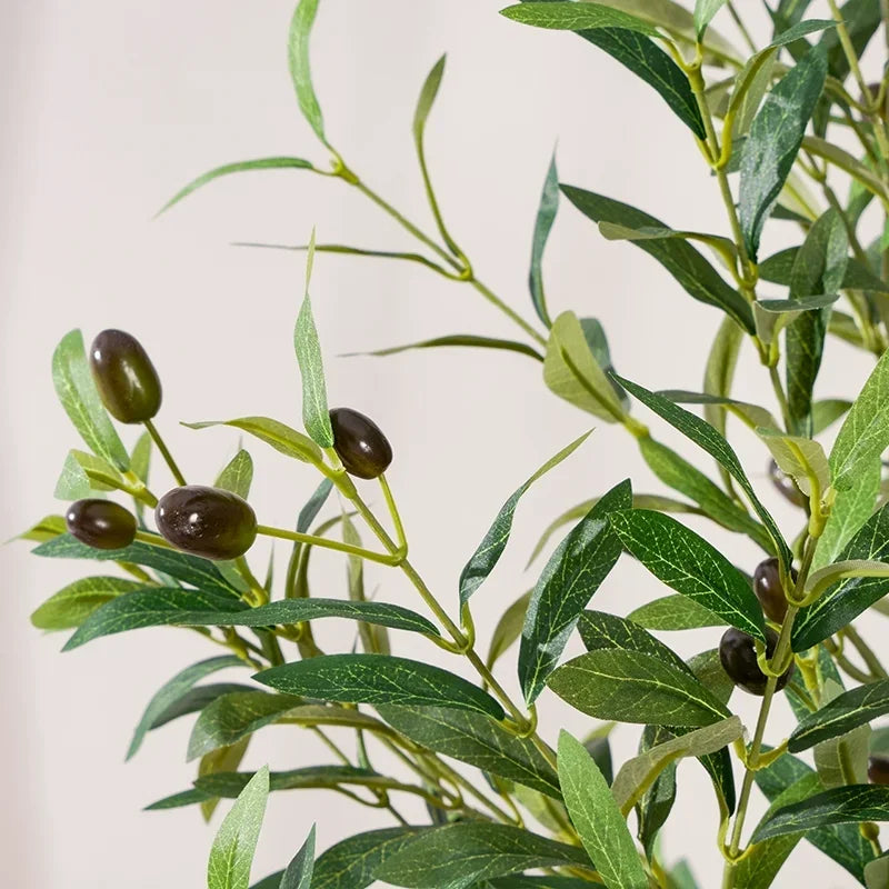 Gros plan de la Plante artificielle extérieur-Olive, présentant des feuilles vertes allongées réalistes et des olives vert foncé parmi le feuillage, sur un fond clair et neutre.