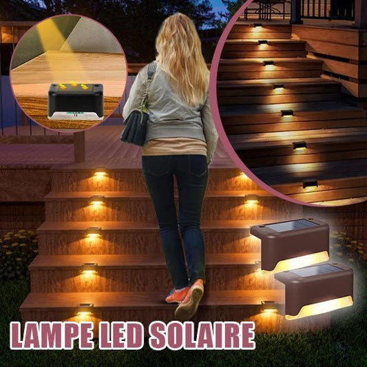 Une femme monte un escalier en bois dans un jardin éclairé par la lampe solaire MagicSolar™. Les images en médaillon illustrent les détails de l'éclairage et la facilité d'installation. Le texte « LAMPE LED SOLAIRE » souligne l'efficacité énergétique de la lampe solaire.